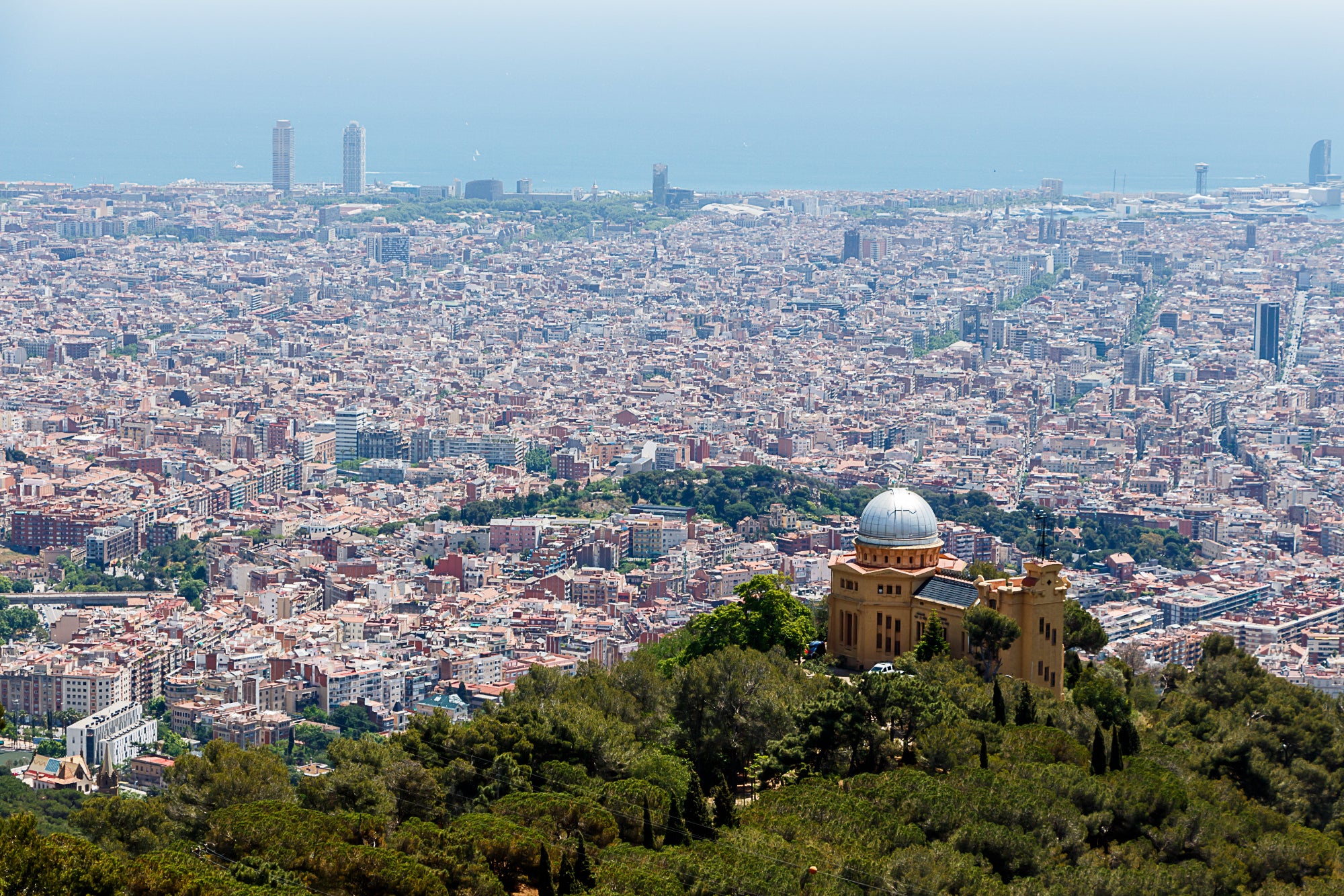 Skyline de Barcelona desde el Tibidabo, con el Observatori Fabra en primer plano y la Sagrada Família al fondo.