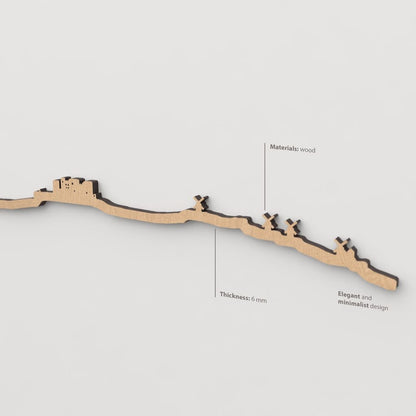 Vista en perspectiva de la silueta del skyline de Consuegra en madera marrón.