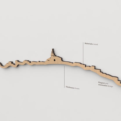 Vista en perspectiva de la silueta del skyline de Cadaqués en madera marrón.