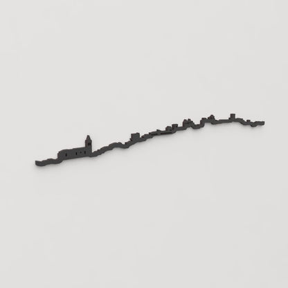 Vista en perspectiva de la silueta del skyline de Cáceres en madera negra.