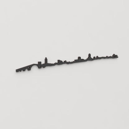 Vista en perspectiva de la silueta del skyline de Camprodon en madera negra.