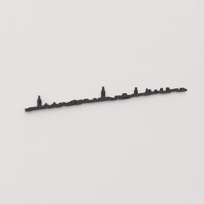 Vista en perspectiva de la silueta del skyline de Ciudad Real en madera negra.